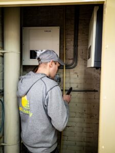 technician inspecting solar power equipment indoors